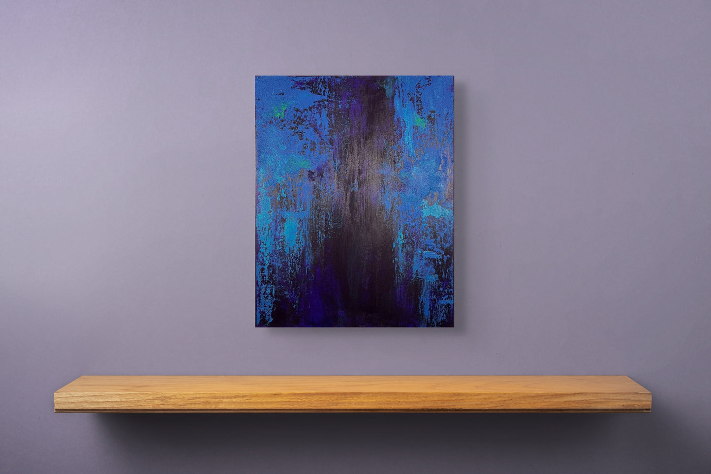 vivi & vela artwork display for 'midnight | moods': abstract artwork styled in a modern interior, showcasing vibrant blue tones and layered textures reminiscent of city lights at night.