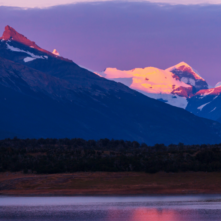 vivi & vela summit inspiration - serene distant mountains reflecting sunset hues over calm waters