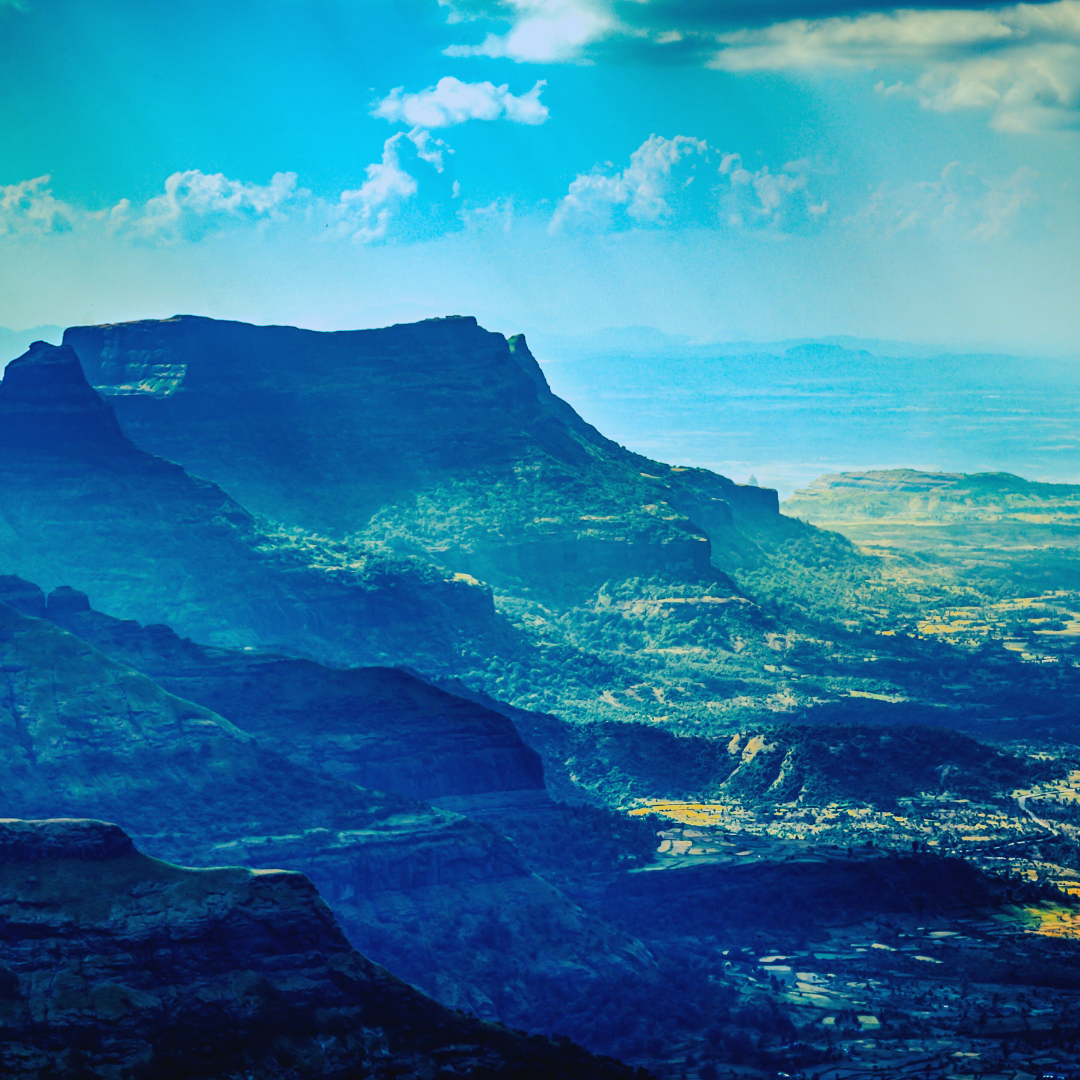 vivi & vela summit inspiration - expansive mountain valley with rolling teal and blue hues under a bright sky